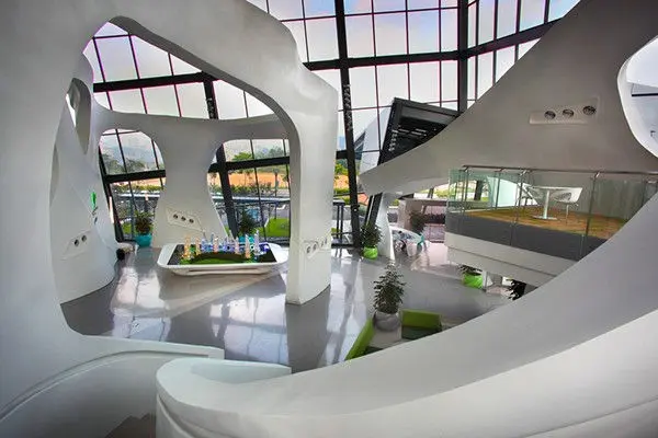 Sales gallery atrium with sculptural white forms and a scale model display