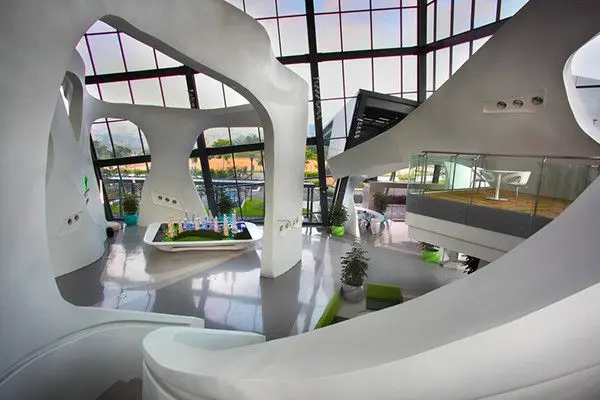 Sales gallery atrium with sculptural white forms and a scale model display