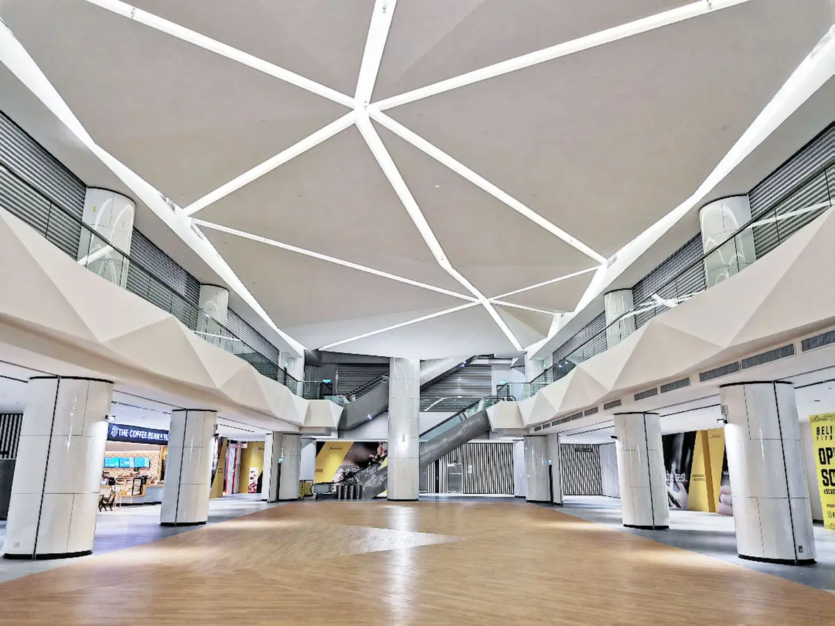 Mall atrium with a geometric ceiling feature and escalators