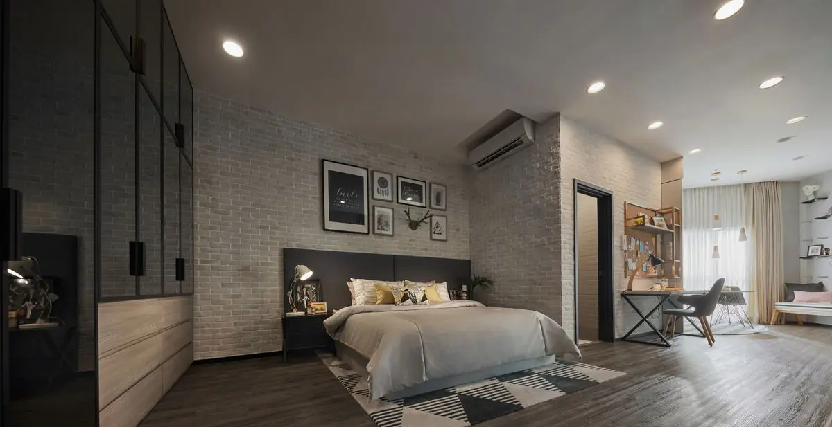 Bedroom with a whitewashed brick wall, gallery frames and a study desk by the window