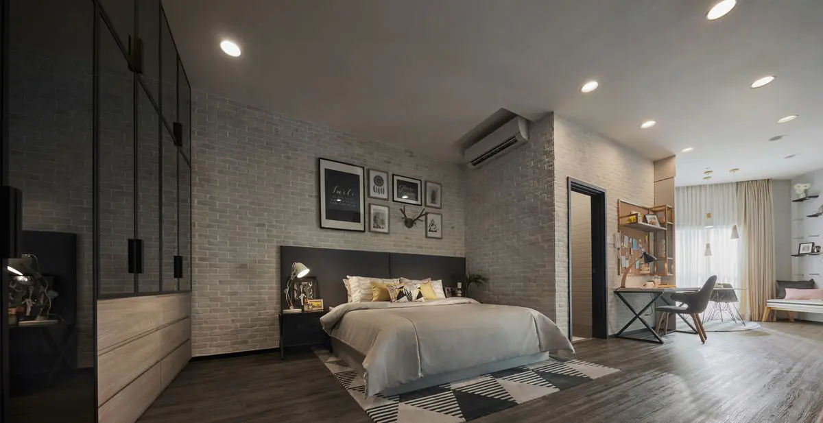 Bedroom with a whitewashed brick wall, gallery frames and a study desk by the window