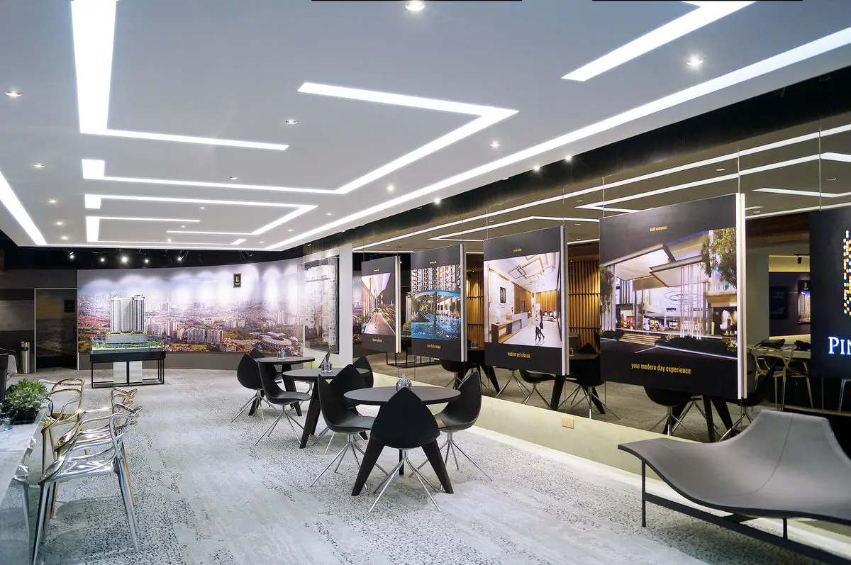Sales gallery with a linear lit ceiling, model displays and lounge seating