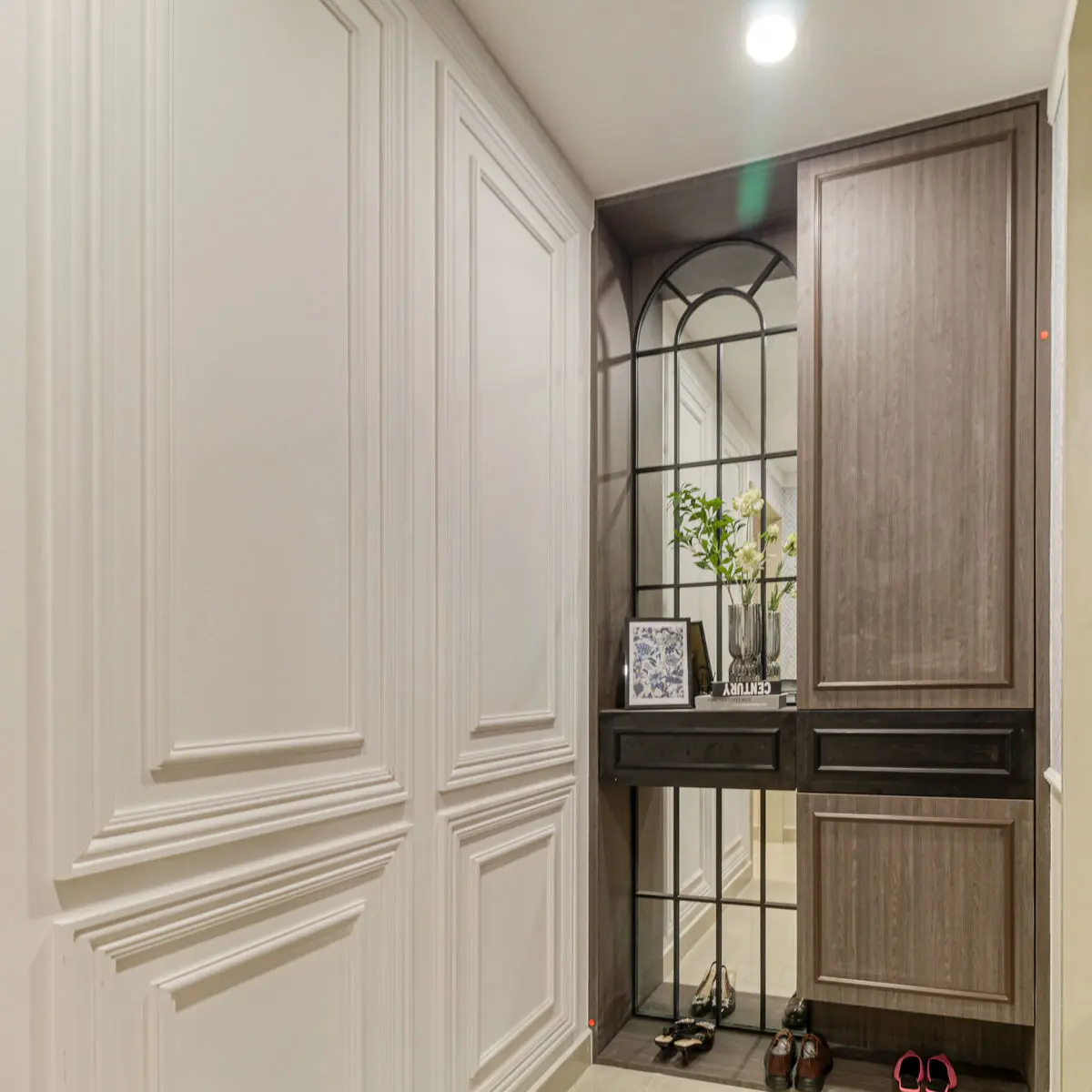 Entrance with an arched glazed screen, panelled walls and a slim console for shoes