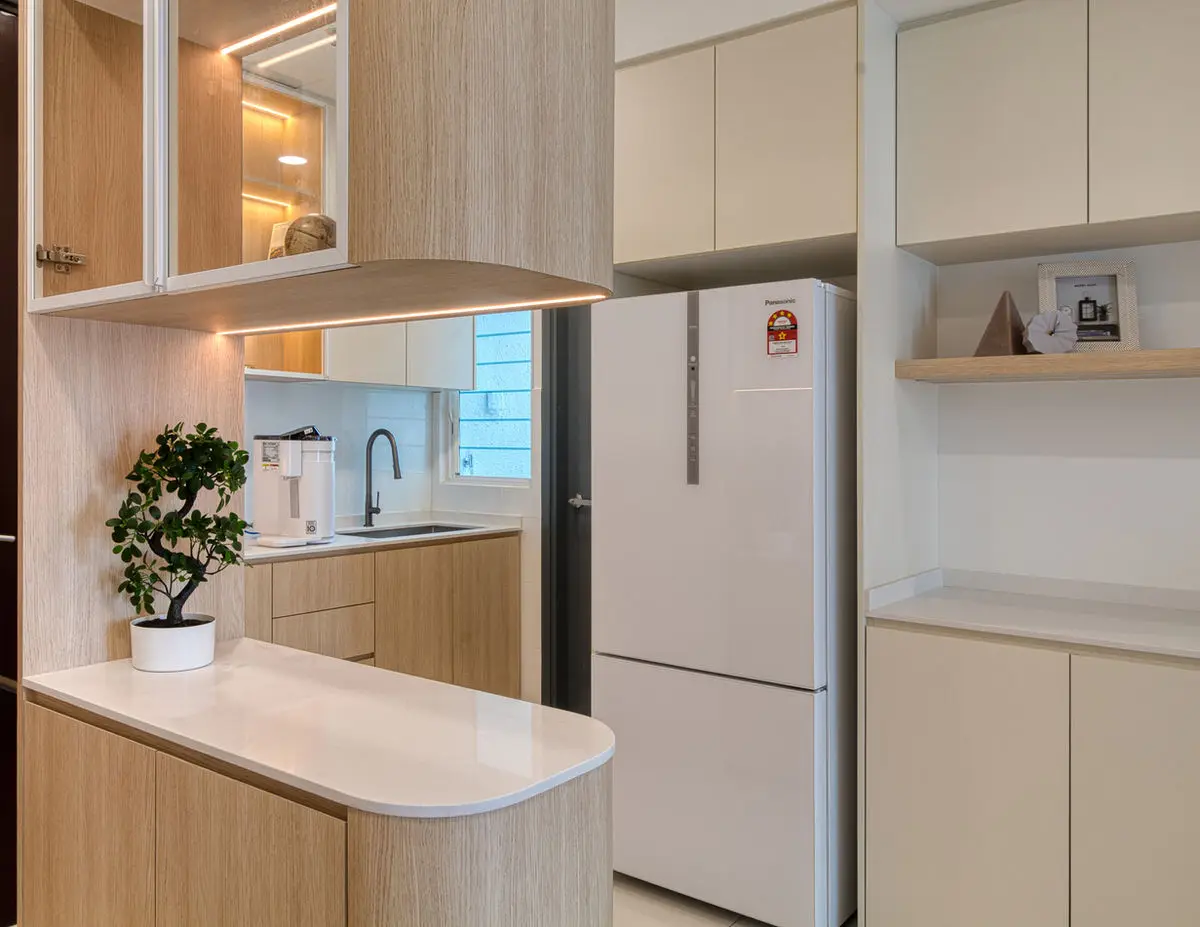 Kitchen with a rounded breakfast counter, tall fridge cabinet and glazed upper units