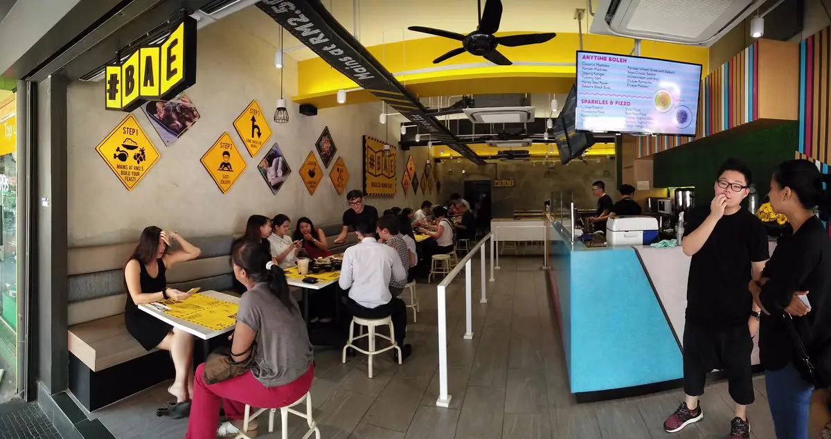 Dining area with hazard-sign wall graphics, banquette seating and diners