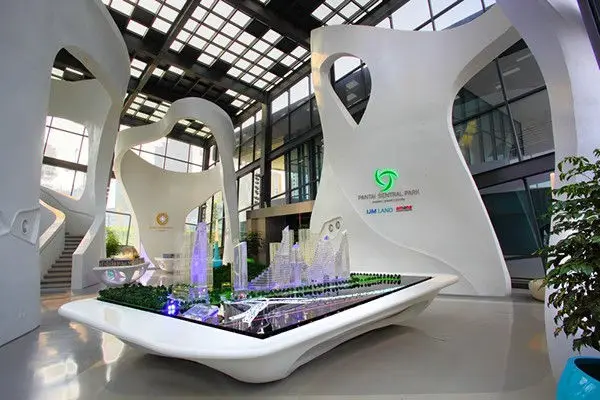 Property scale model on a curved white plinth beneath a glazed roof