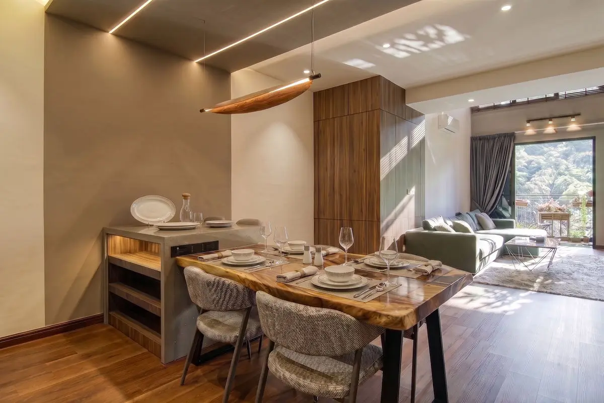 Dining area with a live-edge timber table, linear lighting and the living room beyond