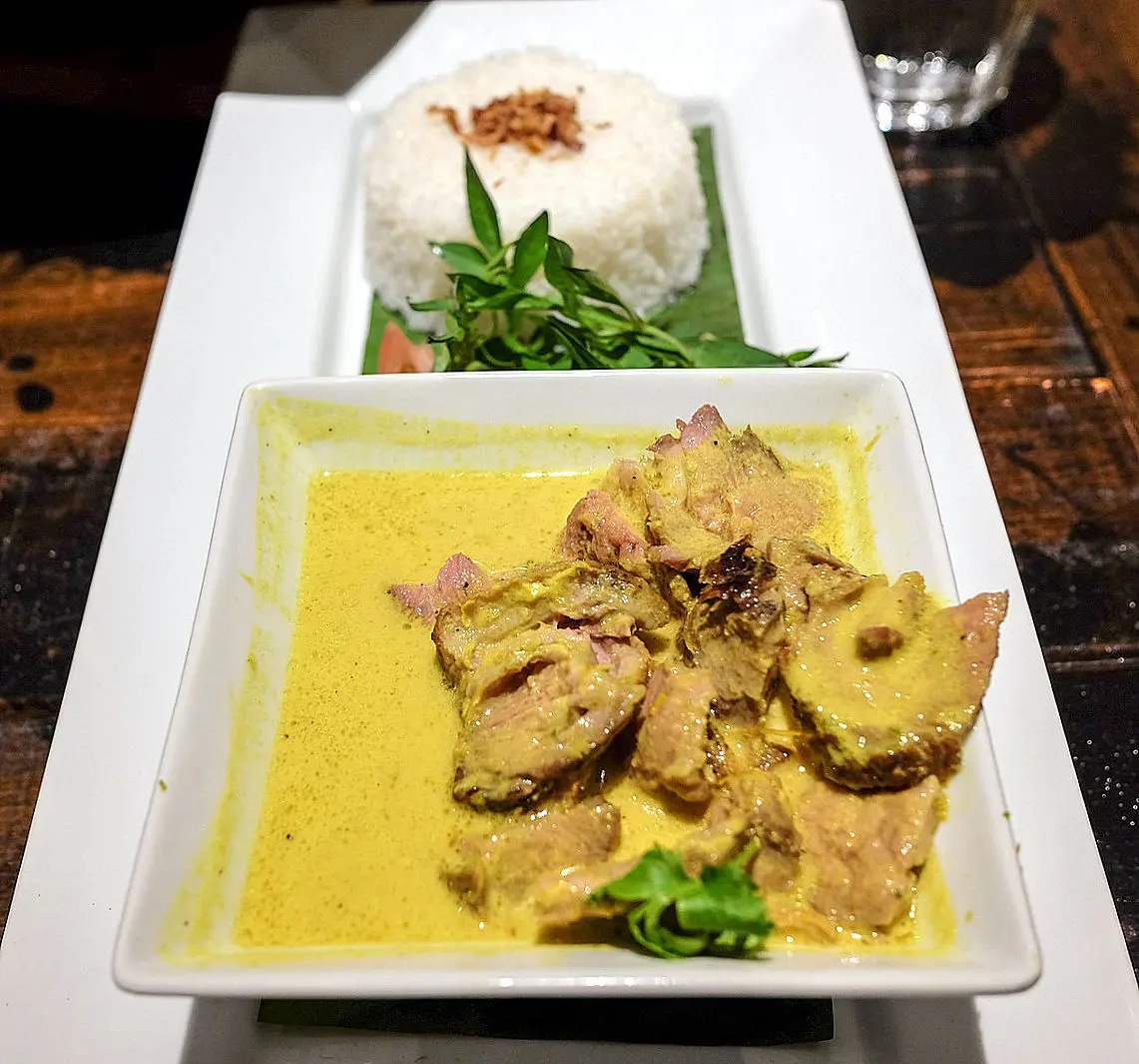 Curry dish served with steamed rice on white platters