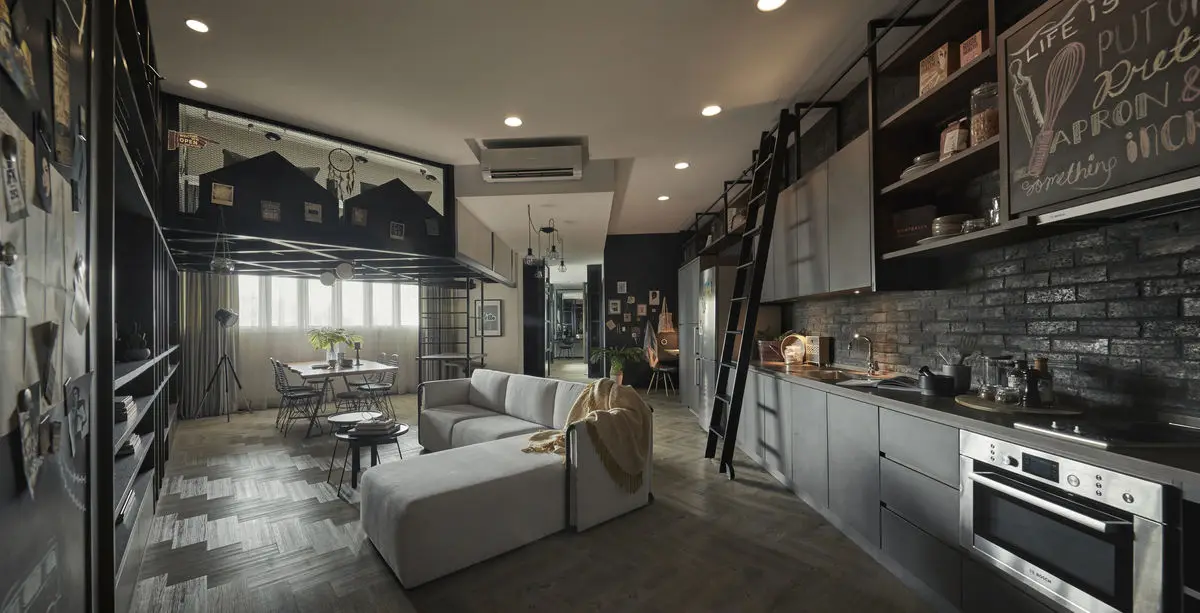 Open-plan loft with a dark kitchen, library ladder, exposed brick and a pale sofa