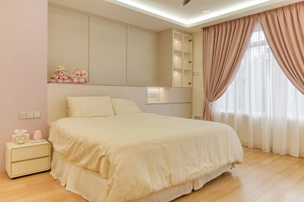 Bedroom with overhead storage above the bed, soft cream bedding and pink drapes