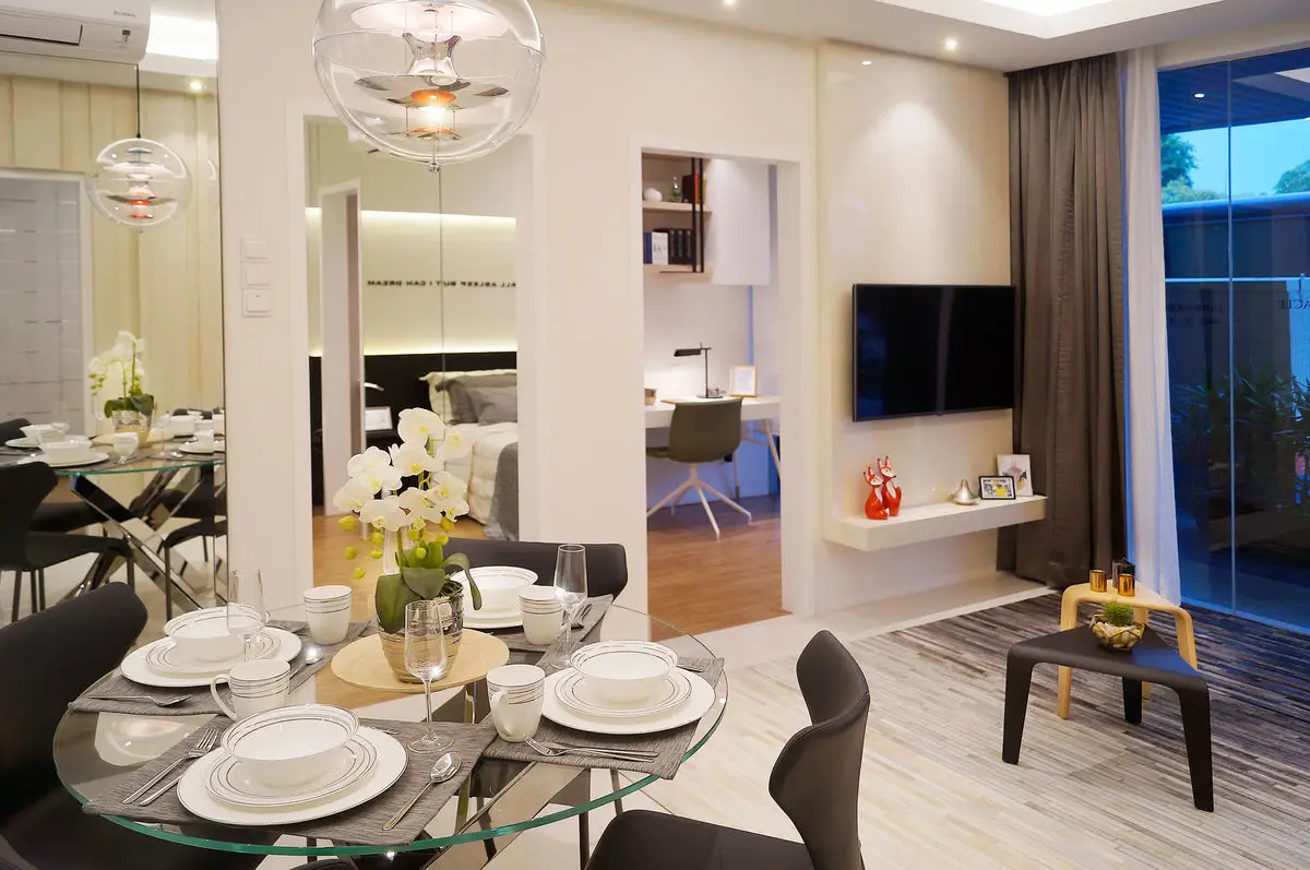 Dining table set with glassware, mirrored wall and living area beyond