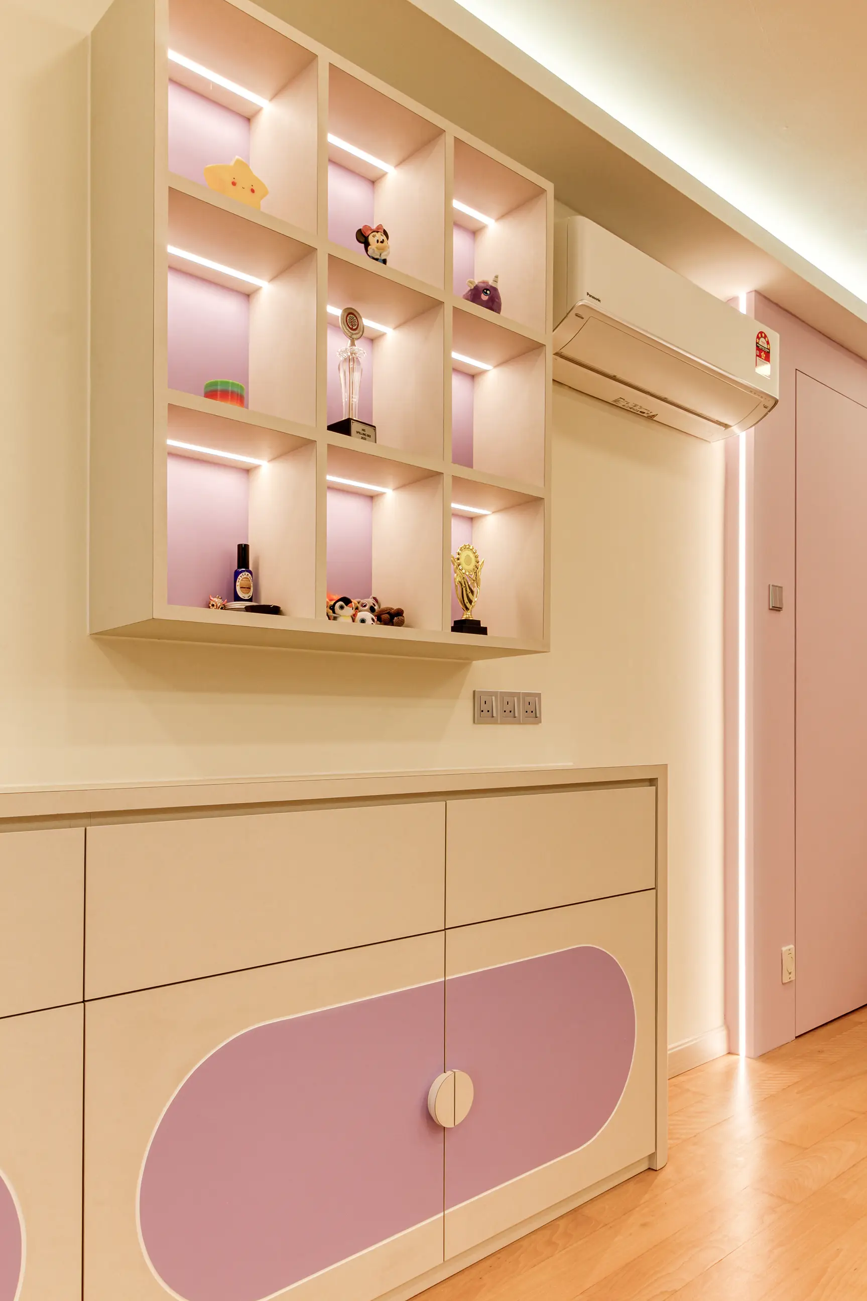 Cream and lilac children’s room joinery with backlit display cubbies and rounded cabinet doors