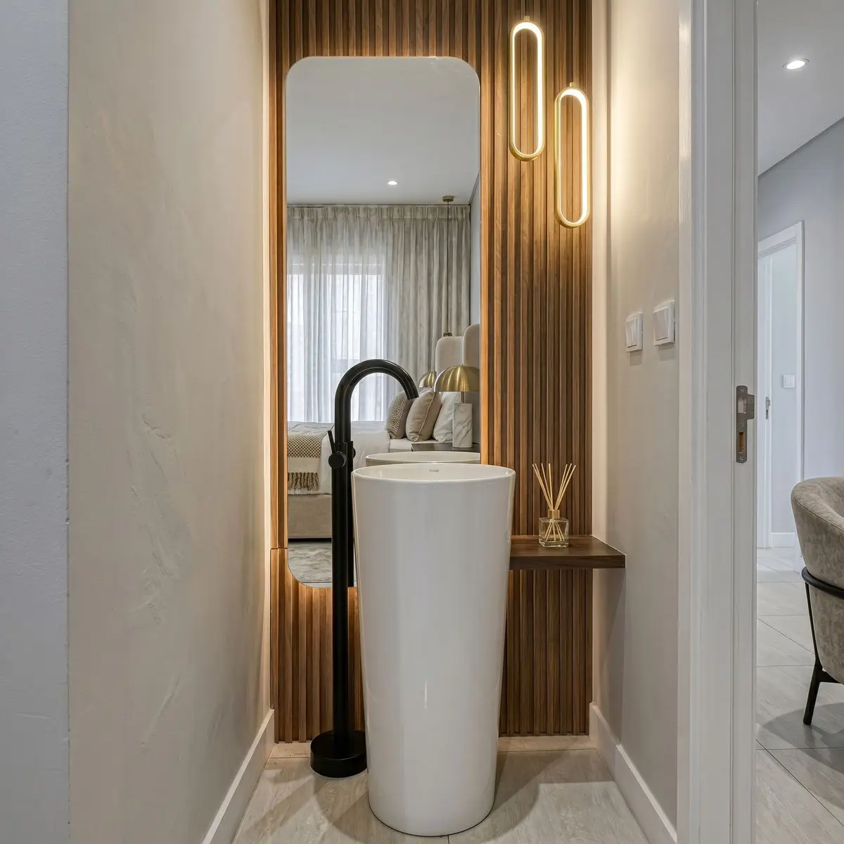 Entrance vignette with a fluted timber panel, tall mirror and a cylindrical console