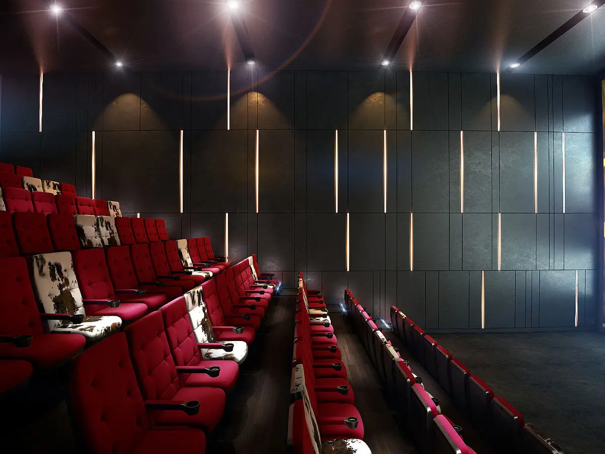 Cinema auditorium with red seating and vertical wall light strips