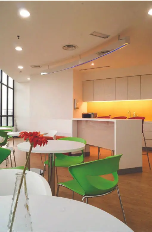 Office pantry with a curved ceiling feature, round tables and green chairs