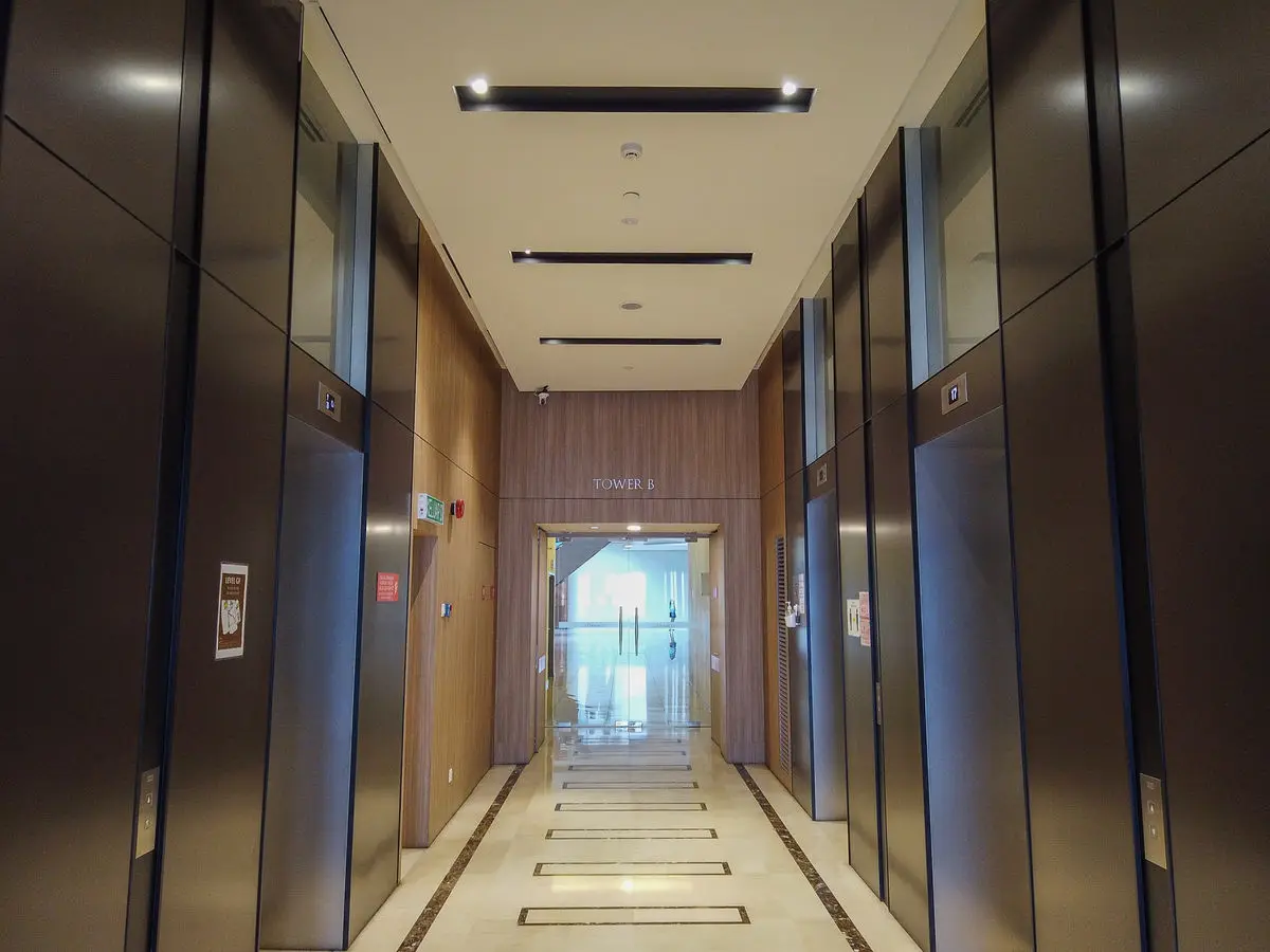 Lift lobby looking through to a bright corridor beyond