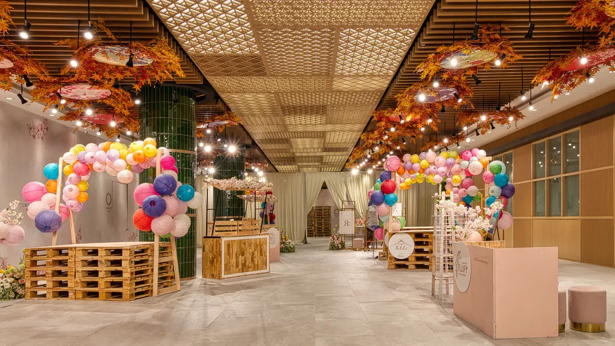 Salon opening event with balloon arches, floral installations and timber counters