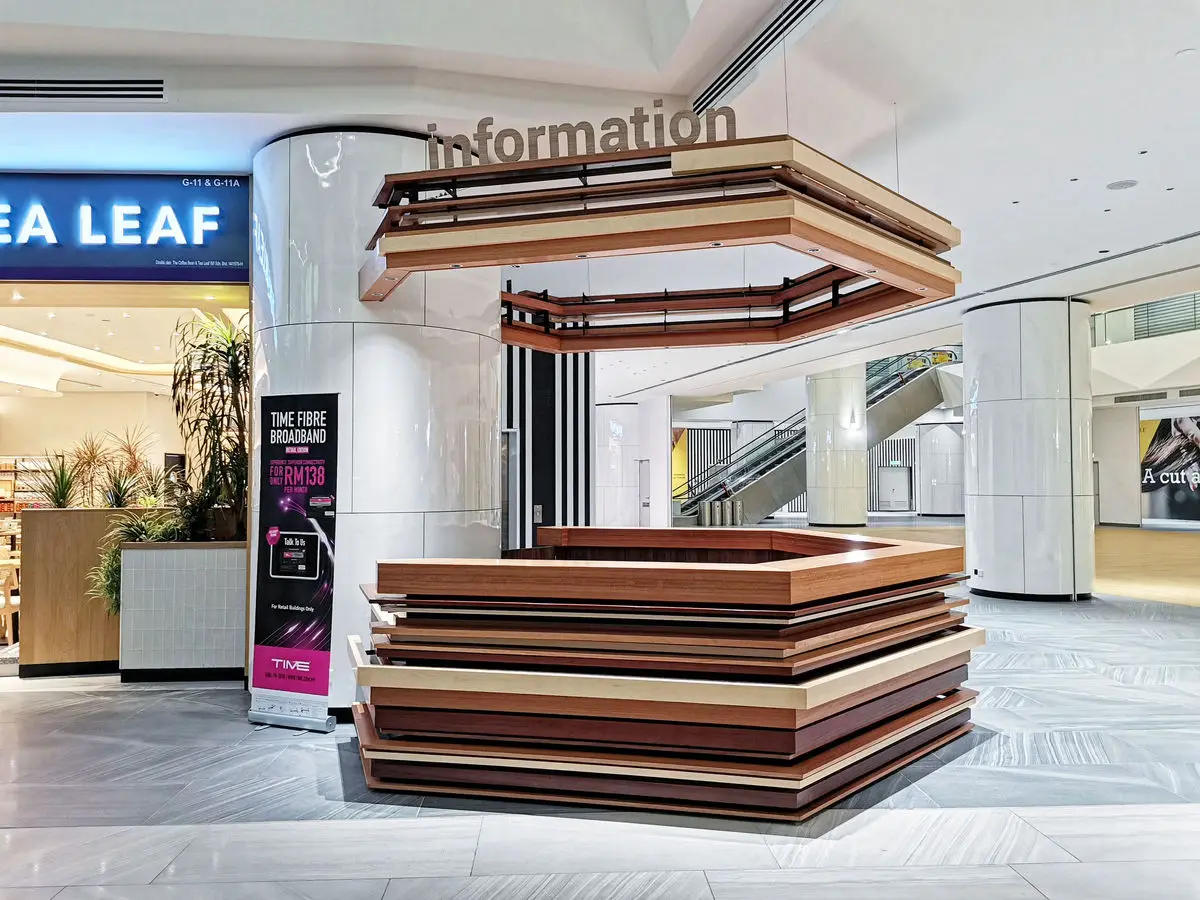 Information counter in timber beneath a layered ceiling feature