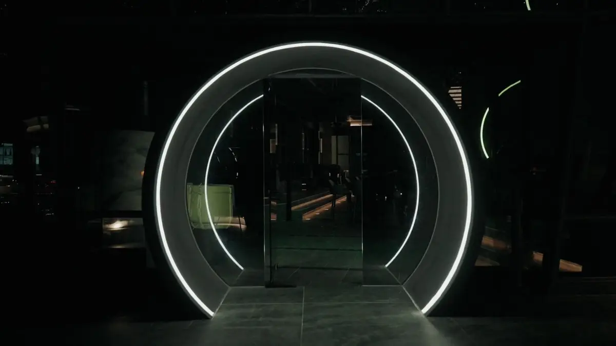 Illuminated circular portal marking the entrance to a dark rooftop lounge