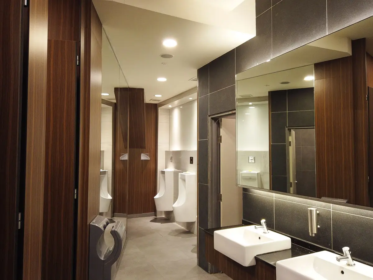 Washroom with timber-panelled cubicles, urinals and wall-hung basins