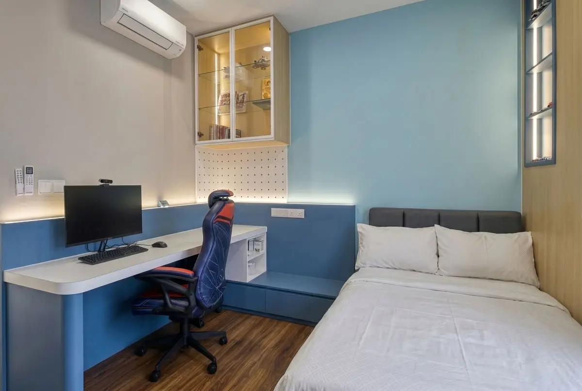 Study bedroom with a blue feature wall, built-in desk and a bed with a padded headboard