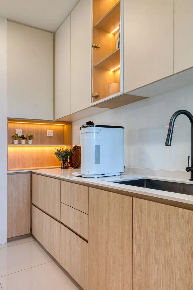 Kitchen counter with a black tap, backlit open shelf and handleless timber drawers