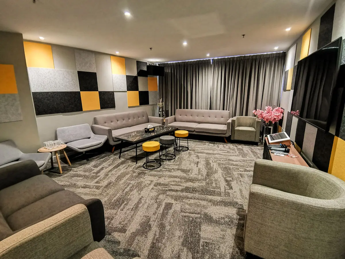 Breakout lounge with checkered acoustic panels, sofas and patterned carpet