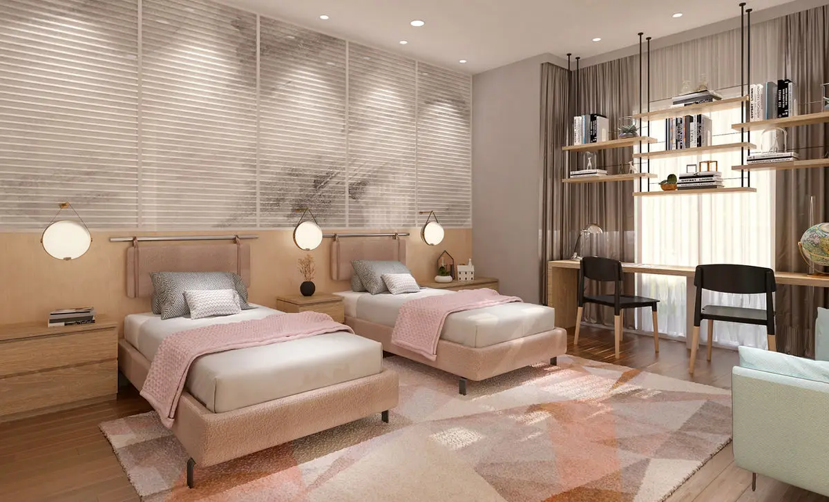 Twin bedroom with pink bedding, fluted wall panelling and a study desk by the window