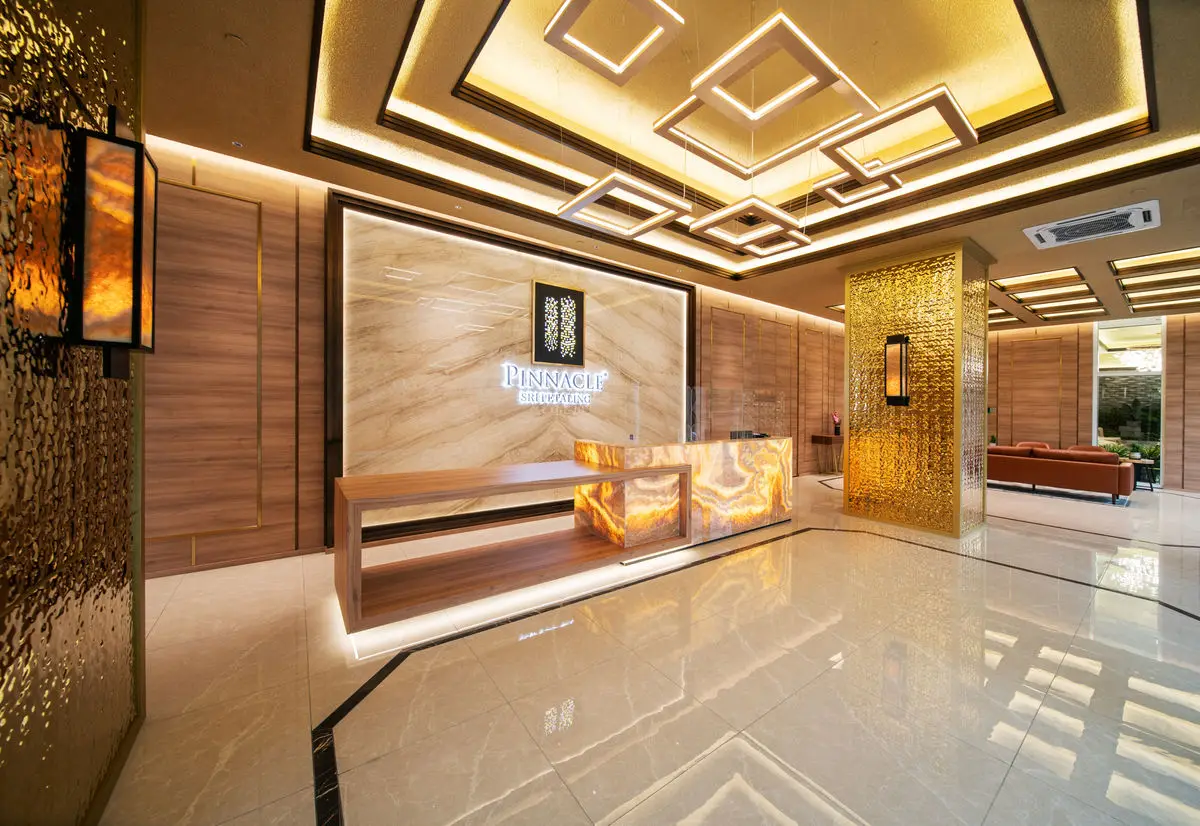 Residential lobby with timber panelling, a reception counter and gold screen detail