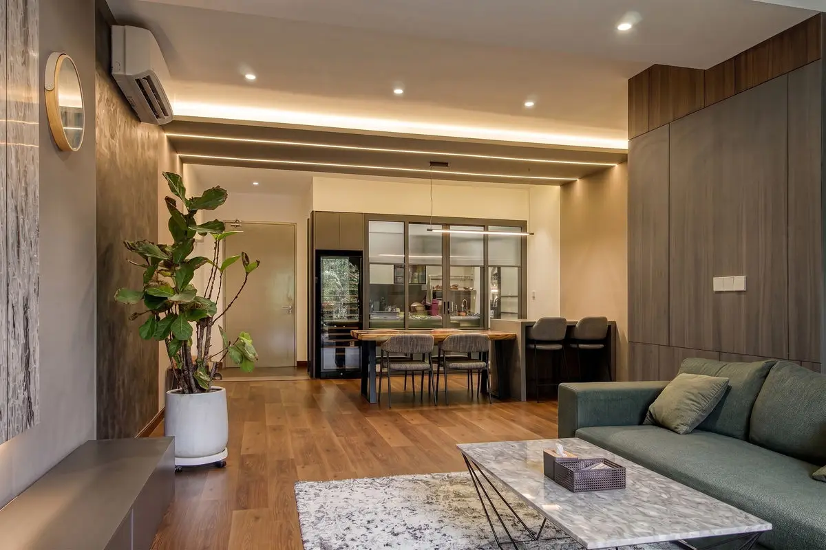 Living room looking through to the dining area, with timber panelling and a green sofa