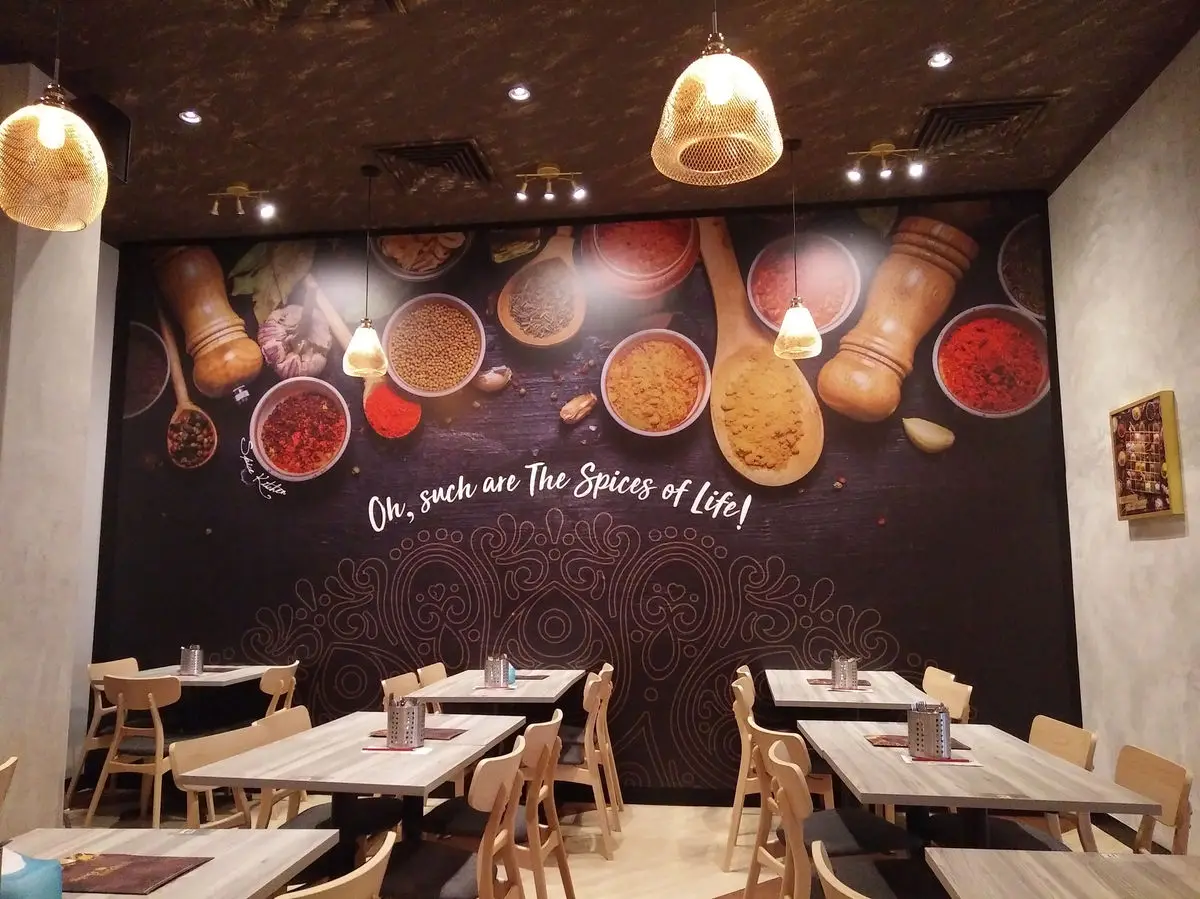 Dining corner with a spice photography mural and timber tables