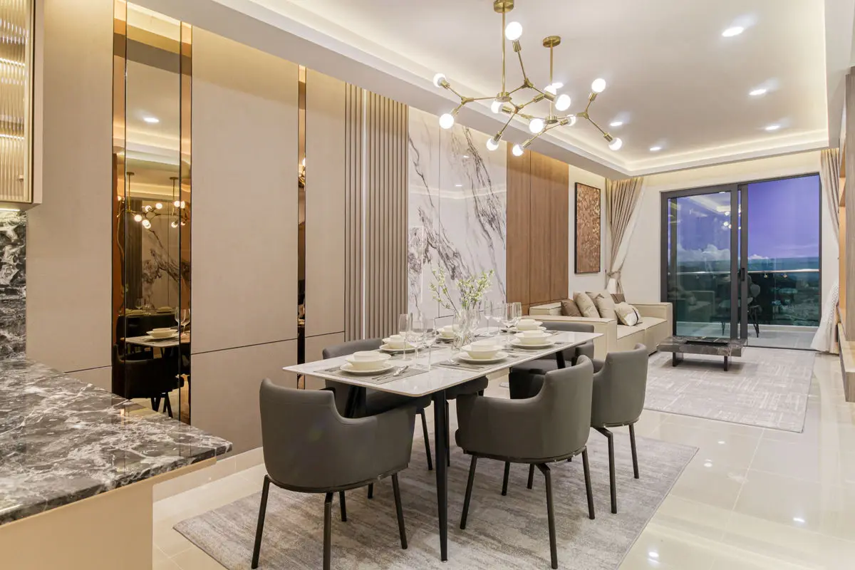 Dining area with a marble backdrop, sputnik chandelier and city view through the window