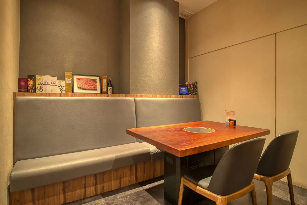 Booth seating with a timber table, grill inset and banquette bench