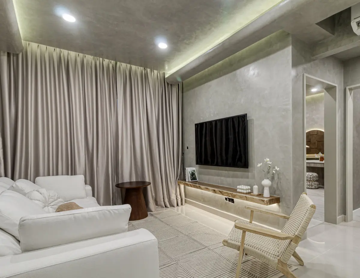 Living room with a wall-mounted TV on a micro-cement wall and a low timber console