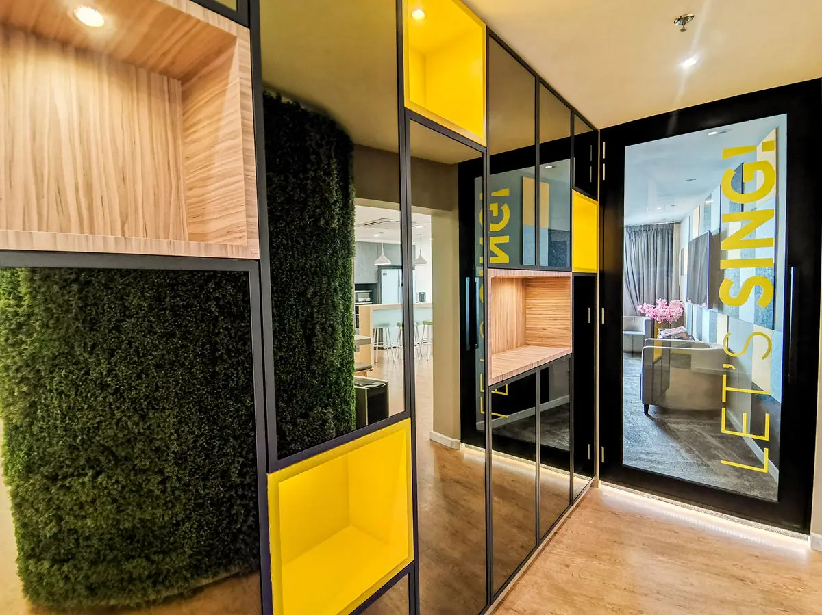 Phone booth and breakout niche with a moss wall and yellow accent seating