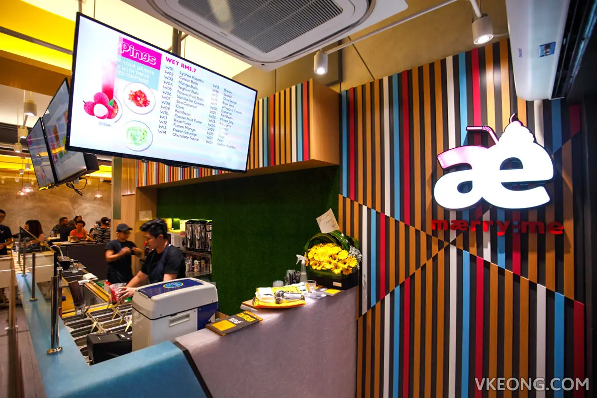 Counter with digital menu screens above a striped feature wall