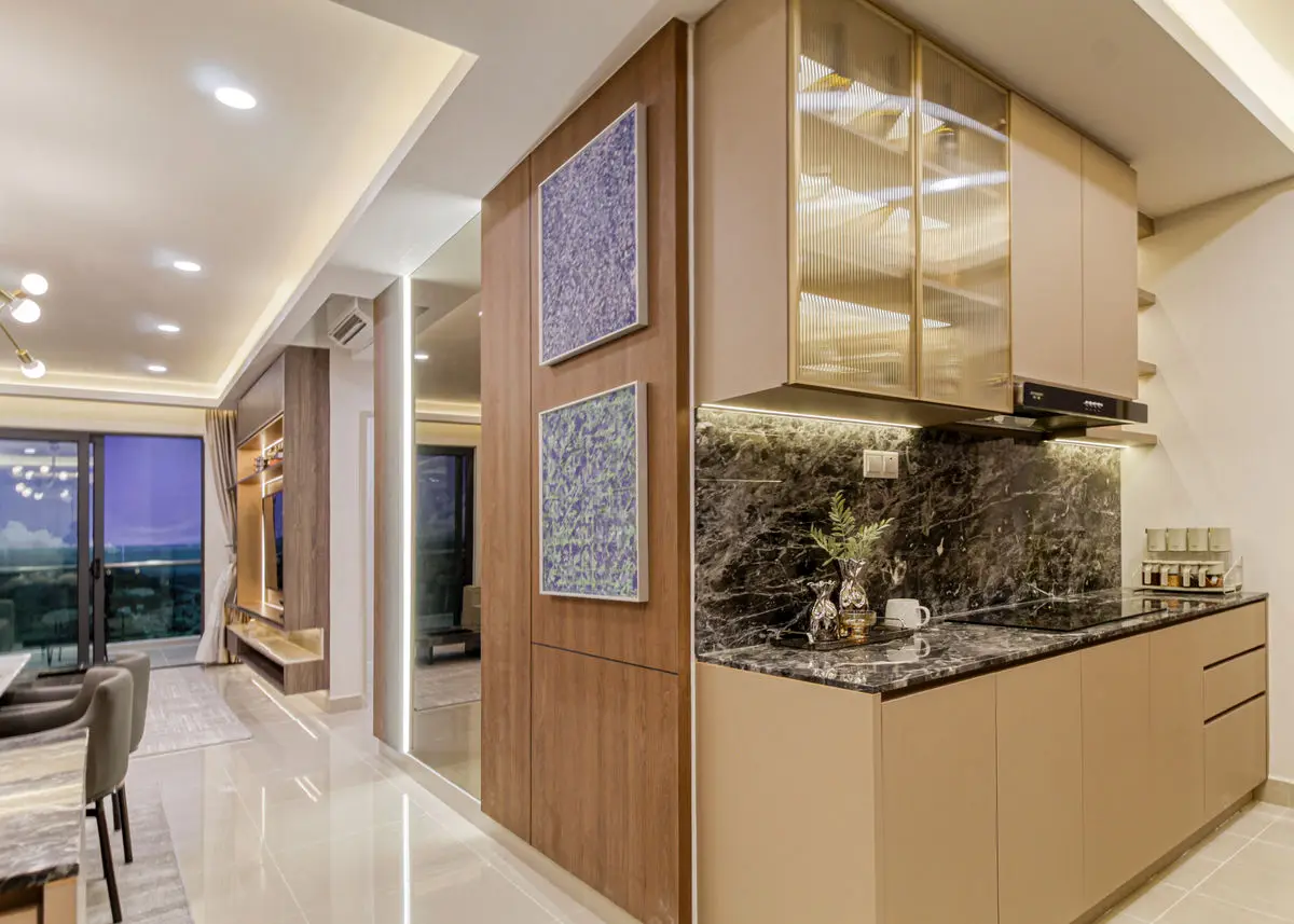 Kitchen with brass-framed glazed cabinets, dark stone backsplash and dining area beyond