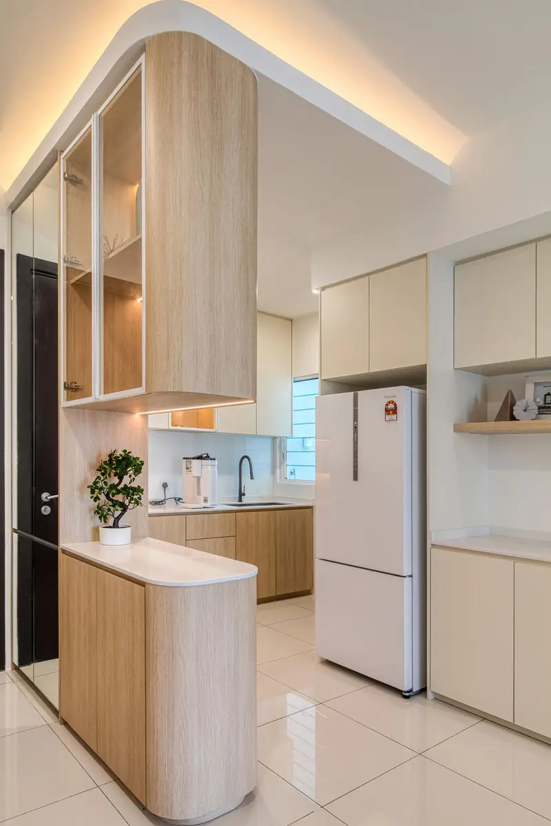 Curved cabinetry framing the kitchen entry, with cove lighting overhead