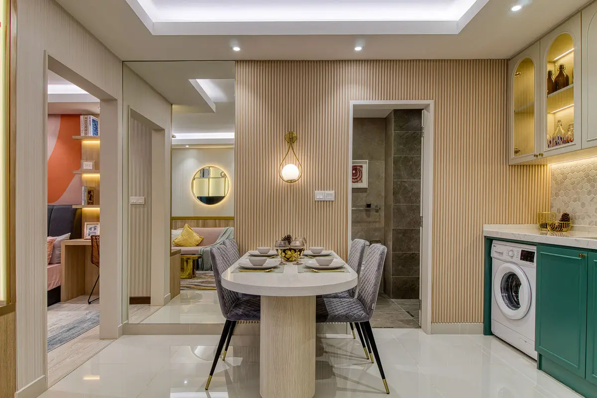 Dining area with utility zone behind, including a washing machine in green cabinetry