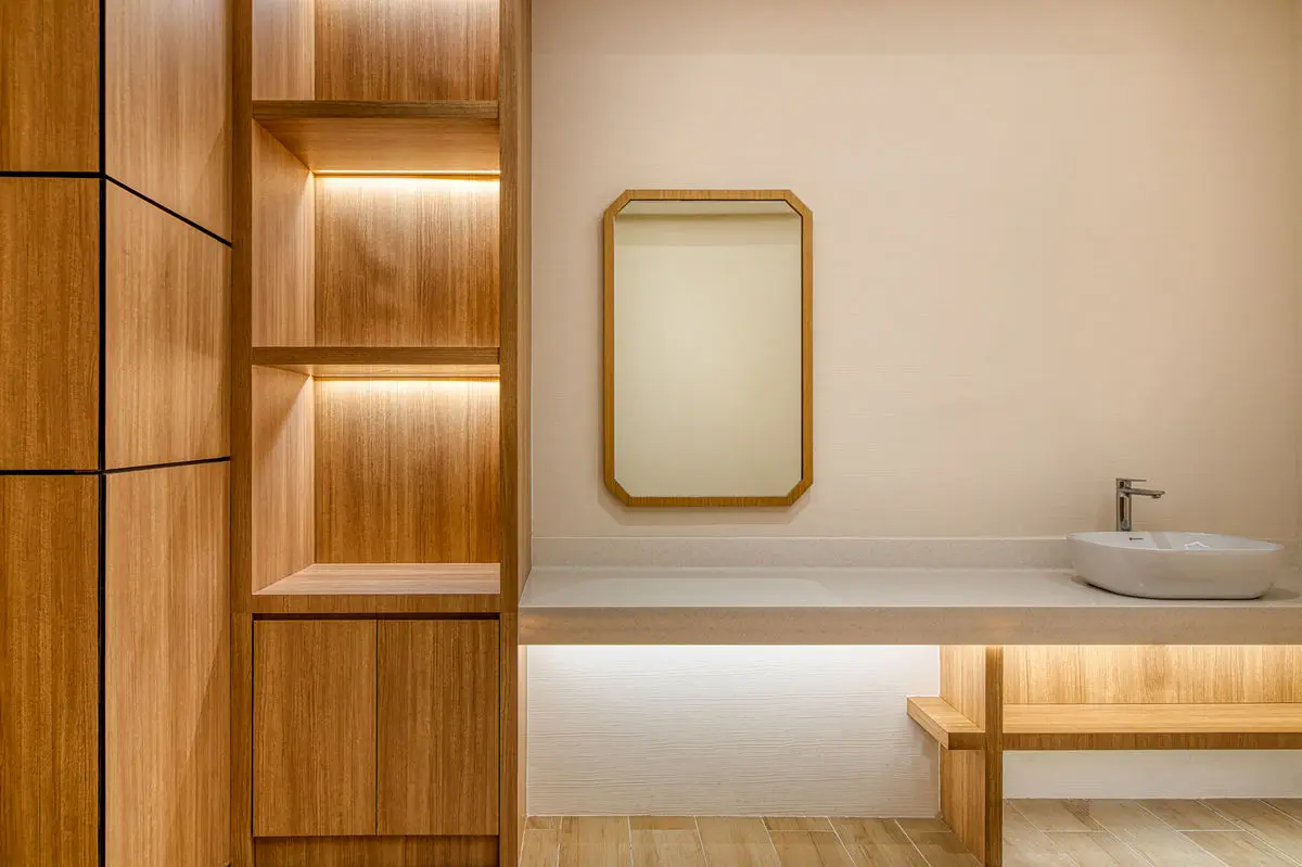 Treatment room detail with open timber shelving, a mirror and a vessel basin