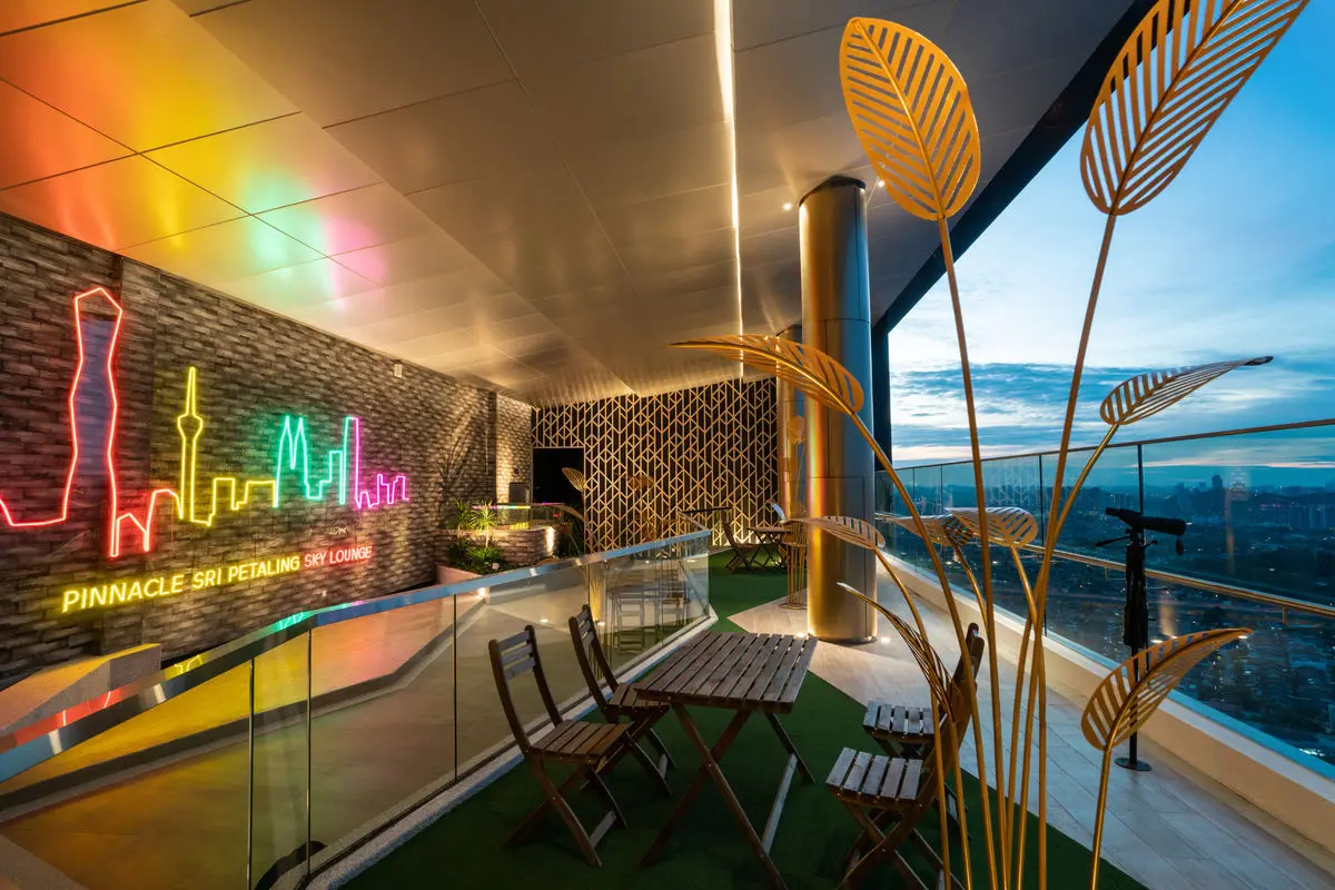 Rooftop terrace with neon skyline artwork, planting and café seating