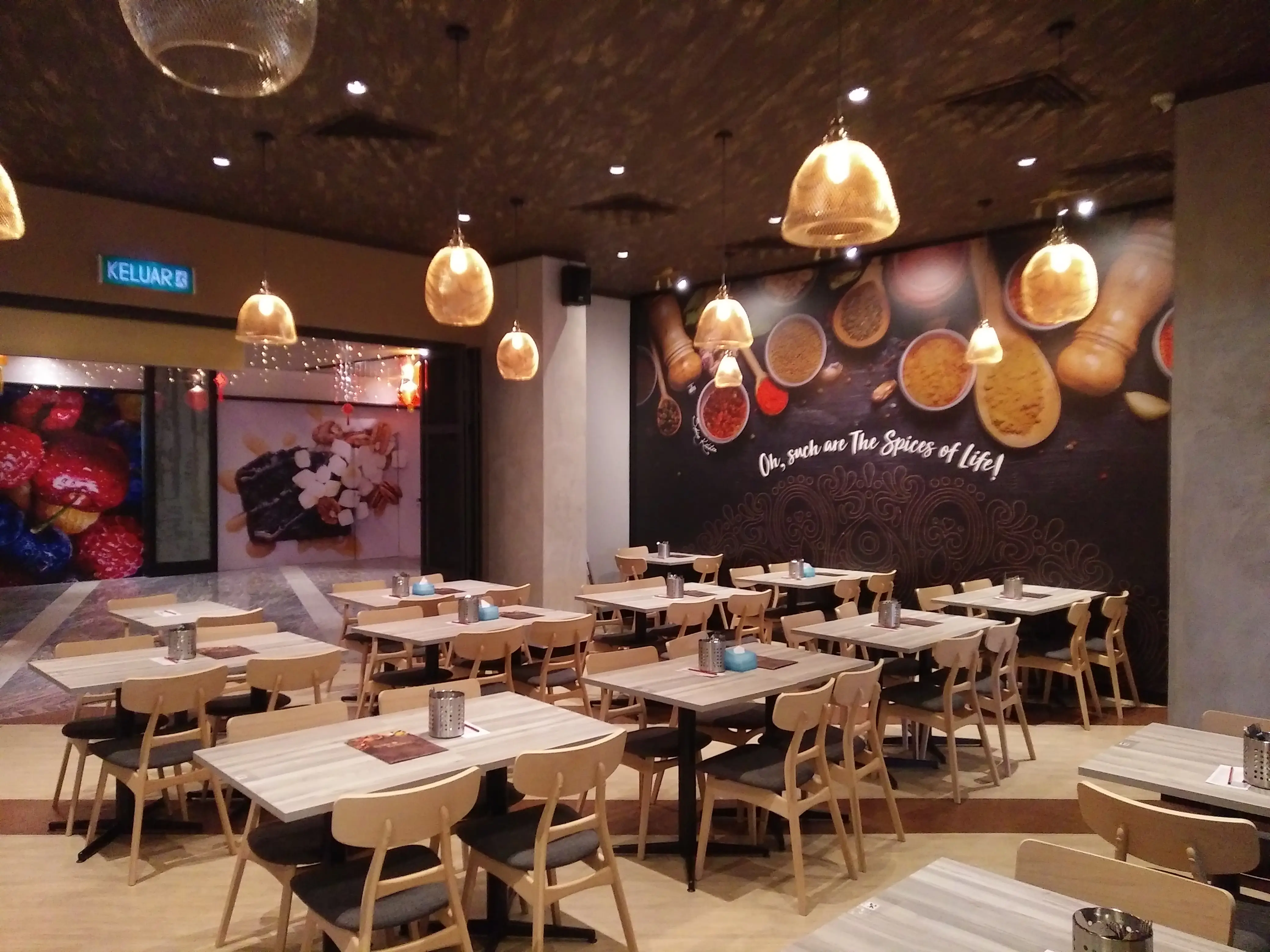 Casual dining room with rattan pendants, spice mural wall and pale timber tables and chairs