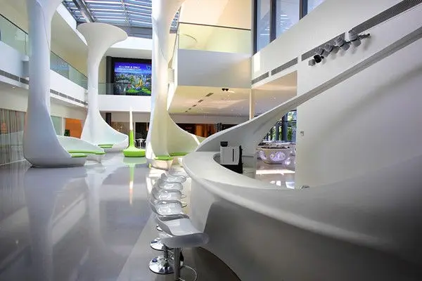 Gallery interior with a curved bar counter, stools and wall-mounted screens