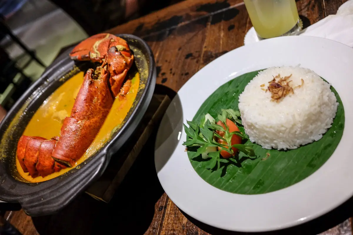 Curry served in a clay pot with rice on a banana leaf