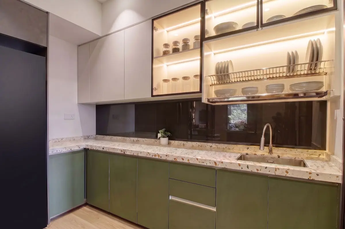 Kitchen with green base cabinets, granite worktop and backlit glazed wall units