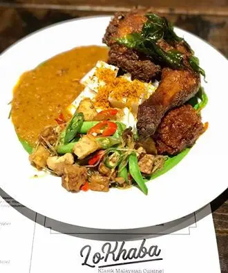 Plated curry with fried chicken and vegetables on a branded placemat