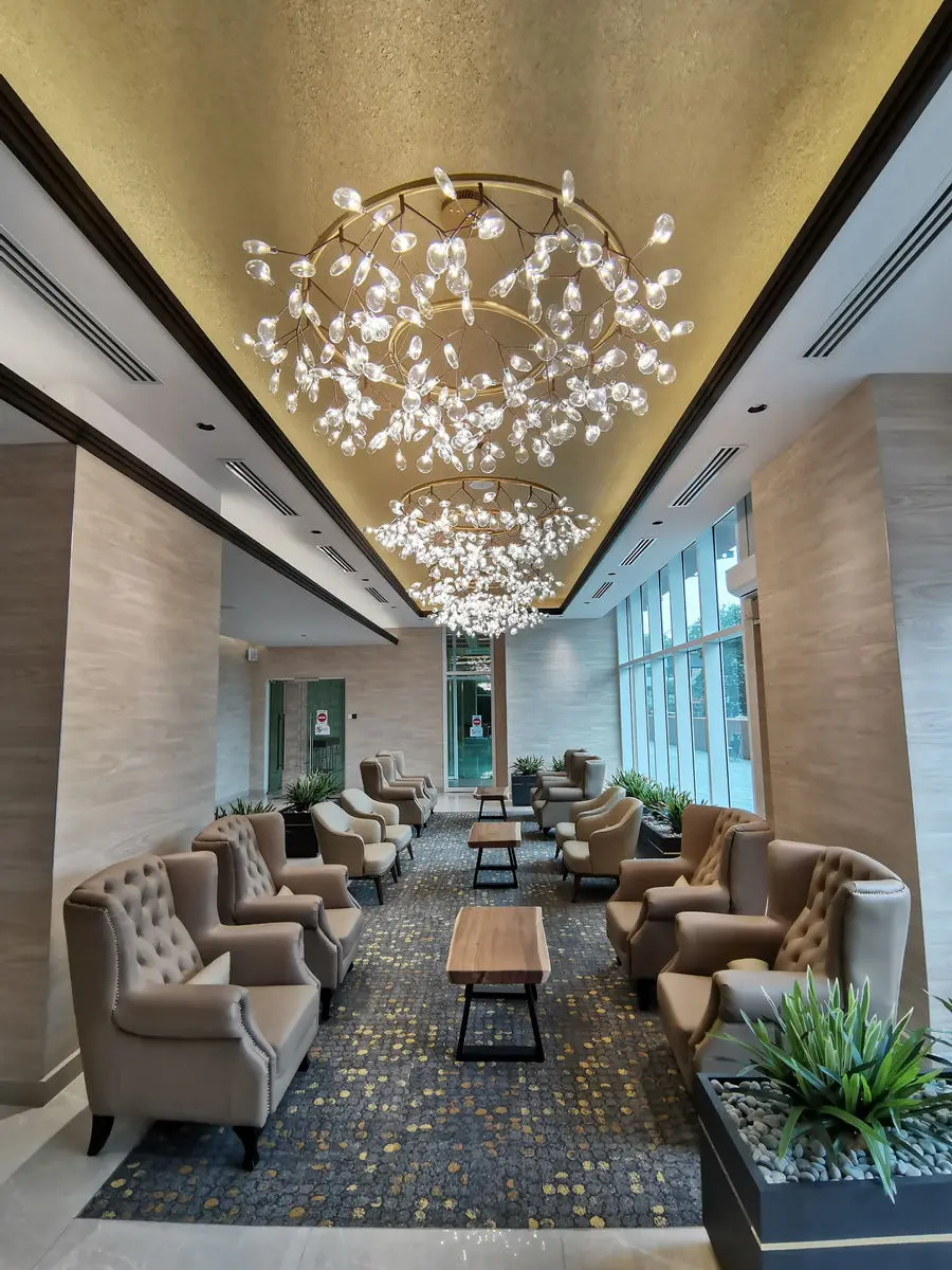 Lounge with a branching chandelier, wing chairs and a patterned carpet