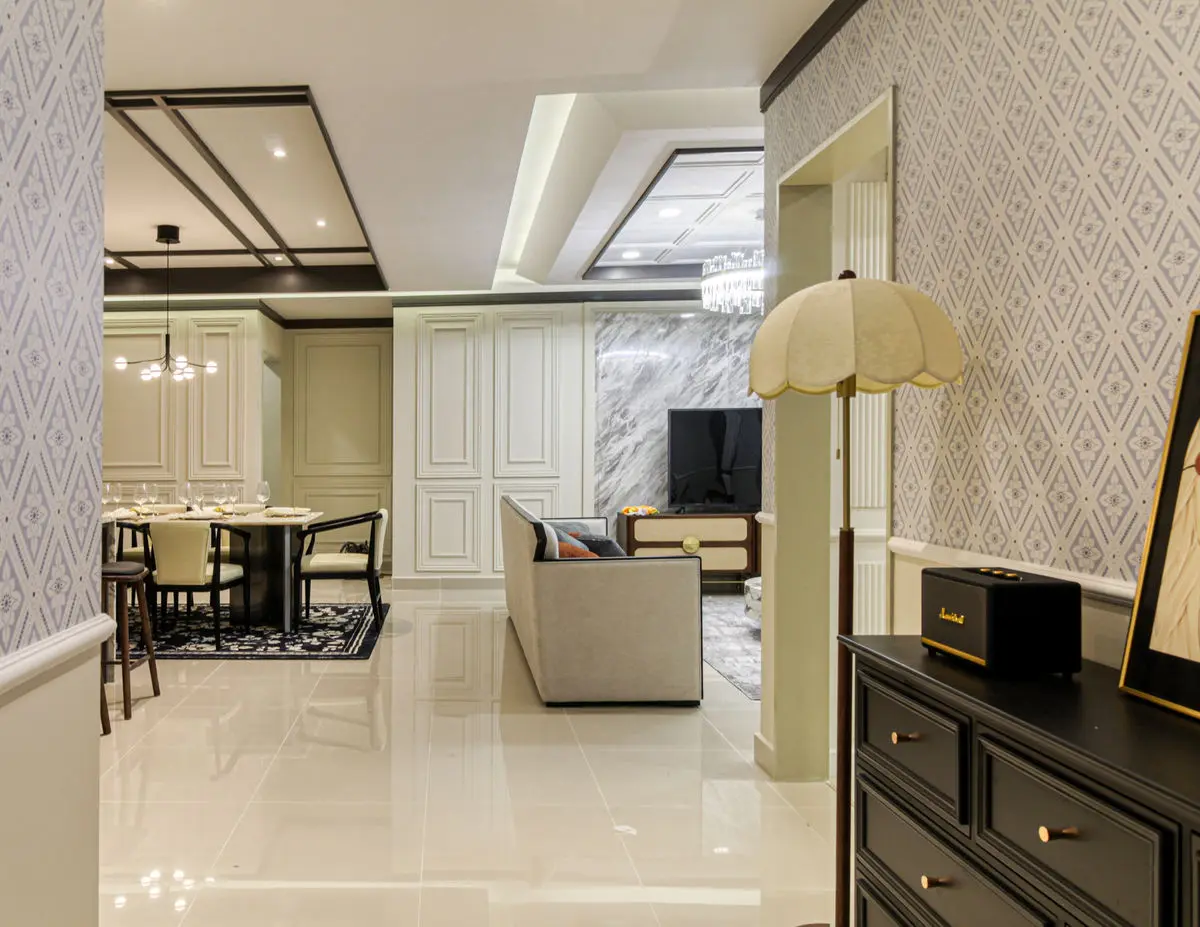 Dining and living area seen past a dark chest, with pendant lighting over the table