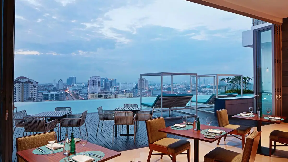 Rooftop terrace dining area with city views and outdoor seating by the pool