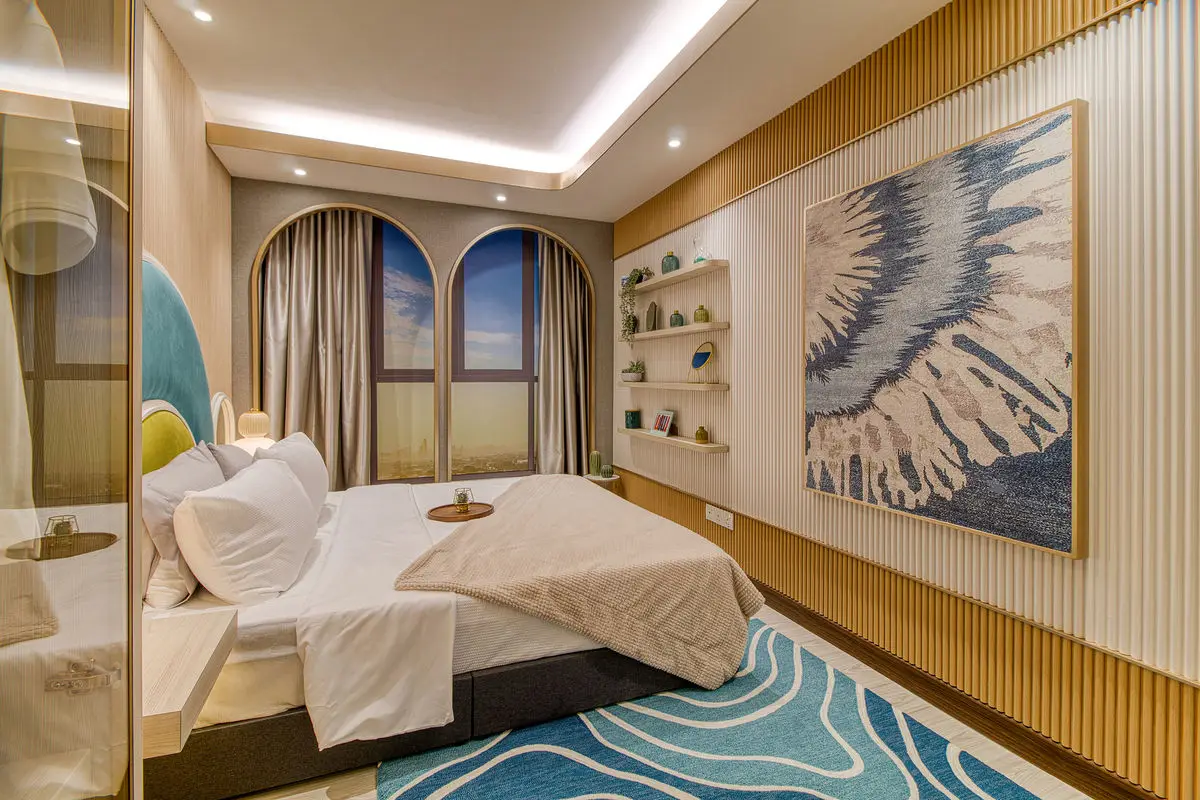 Bedroom with an arched headboard, framed artwork and fluted timber walls